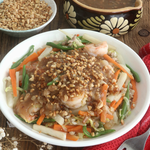 Lumpiang hubad in a serving plate topped with lumpia sauce and garnished with ground peanut.