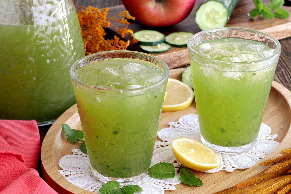 Cucumber juice served in glasses with mint leaves and sliced lemon.