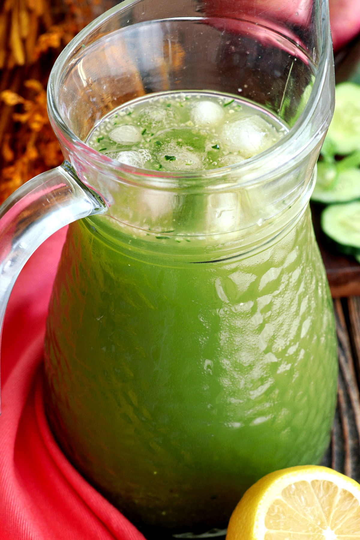 Cucumber juice in a pitcher with ice cubes.