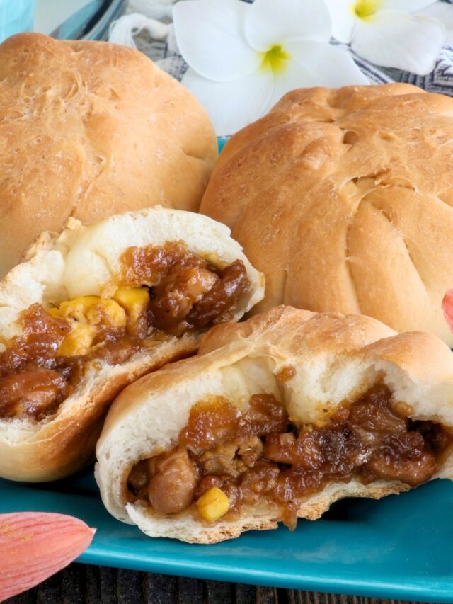 Siopao Tostado in half with chicken asado and hard-boiled egg filling.