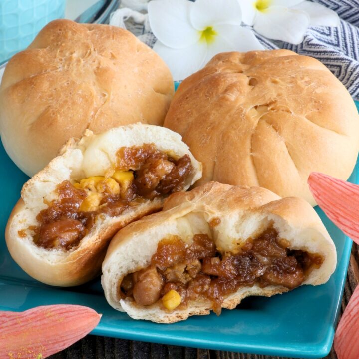 Siopao Tostado in half with chicken asado and hard-boiled egg filling.
