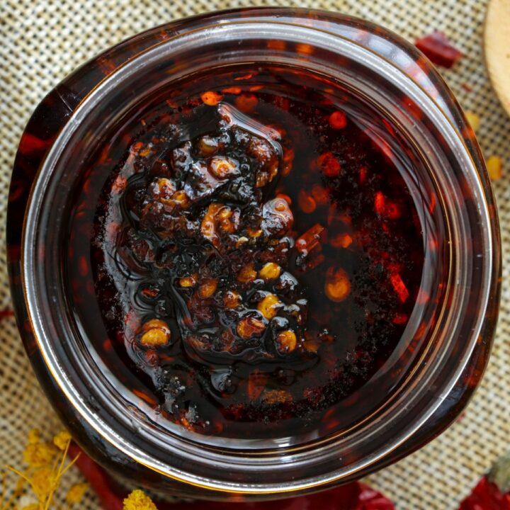 Chili oil in jars with dried chilis on the side.