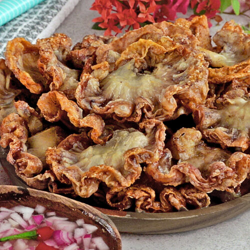 Chicharon bulaklak on a serving plate with spiced vinegar dipping sauce.