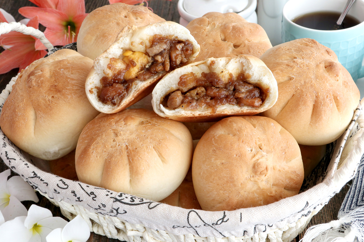 Siopao Tostado in a bread basket basked until crisp, golden brown with chicken asado and hard-boiled egg filling.